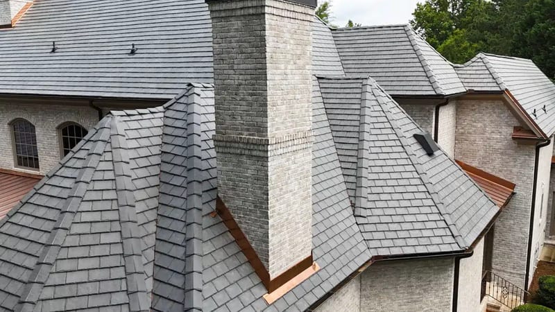 DaVinci composite slate roof in grey with copper flashing around a brick chimney