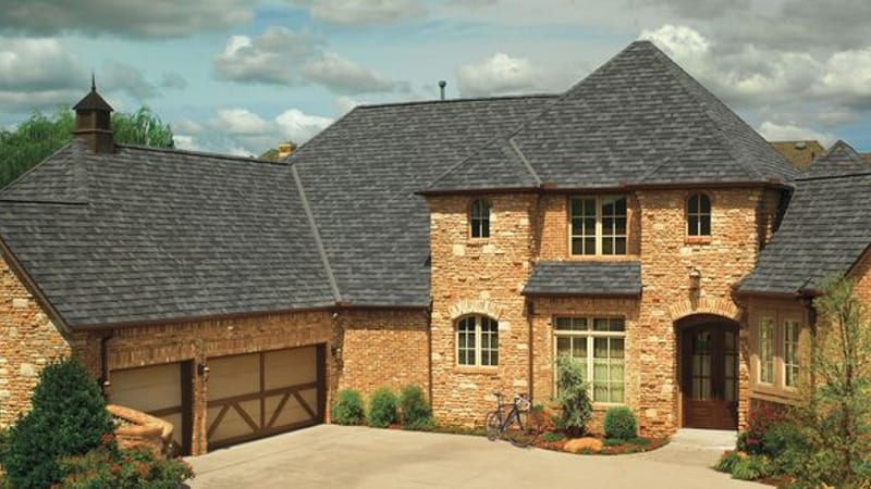 A stone two-storey home with a GAF Camelot designer shingle roof