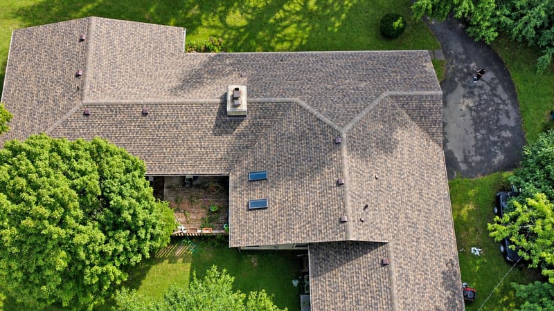 A finished GAF architectural shingle roof in brown and charcoal, from above